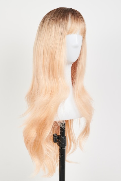 Peruca loira de aparência natural em cabeça de manequim branca Cabelos longos no suporte de peruca de plástico isolado em fundo branco