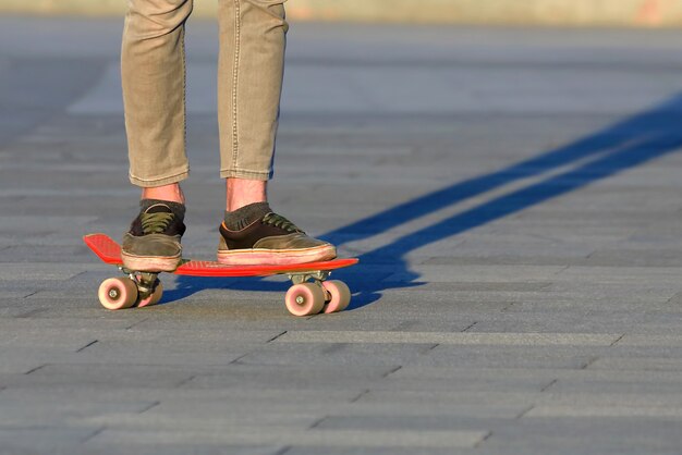 Pés adolescentes de skate na cidade. Hobbies e recreação de adolescentes