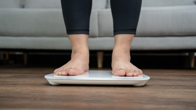 Foto pés apoiados em balanças eletrônicas para controle de peso instrumento de medição em quilograma para controle de dieta