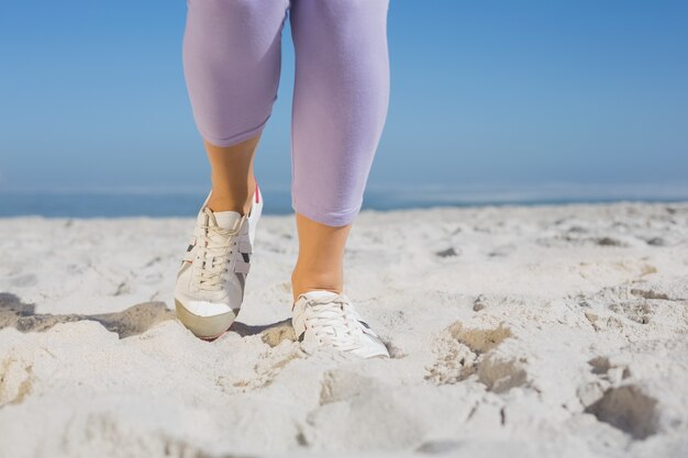 Pés da mulher desportivos na areia