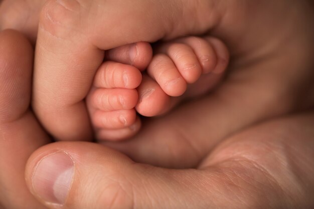 Pés das crianças nas mãos da mãe e do pai. Mãe, pai e filho. Conceito de pessoas de família feliz. Foto de alta qualidade