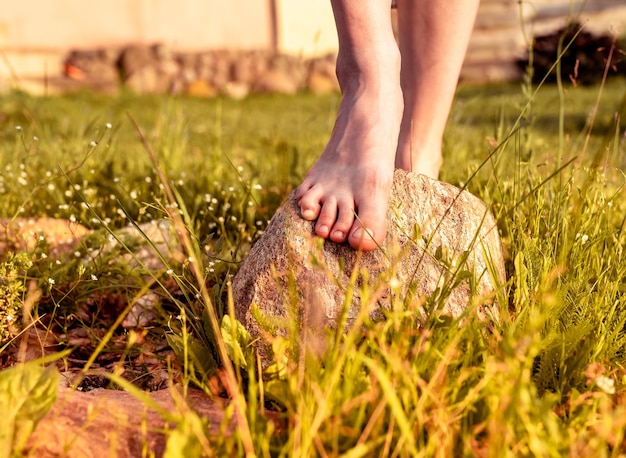 Pés das meninas na pedra natural na natureza Pernas descalças das mulheres ao ar livre