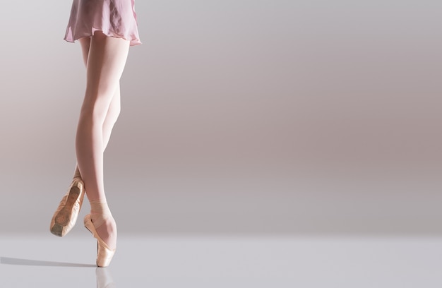 Foto pés de bailarina em sapatilhas de ponta isolados em um espaço em branco
