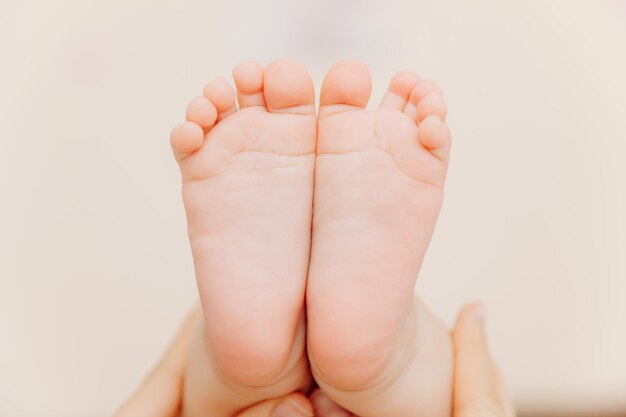 Pés de bebê nas mãos da mãe Mãe e seu filho conceito de família feliz pés de bebê