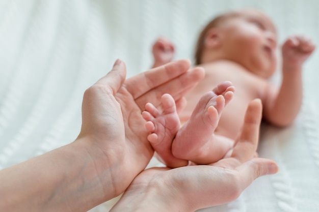 Pés de bebê nas mãos da mãe