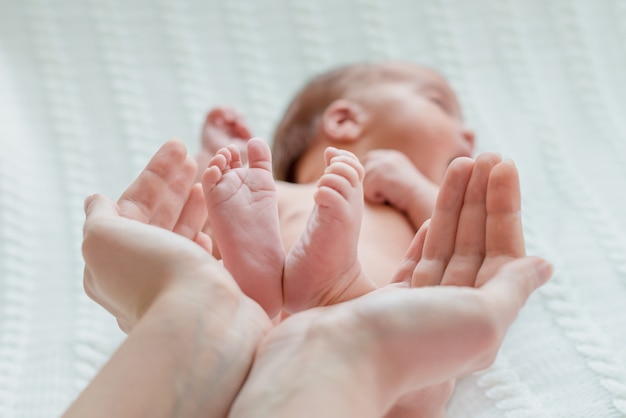 Pés de bebê nas mãos da mãe