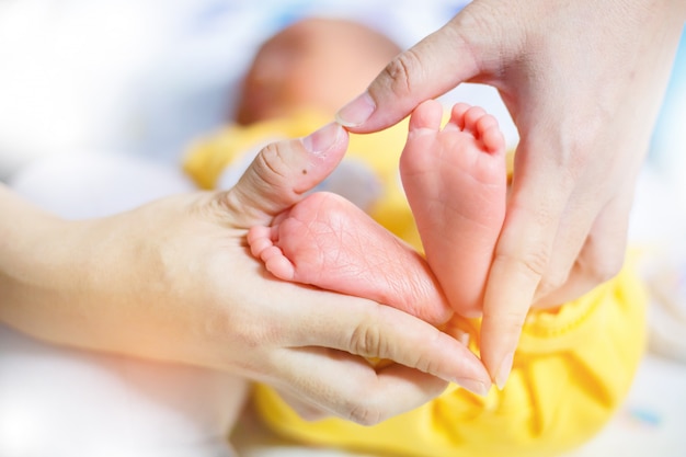 Pés de bebê nas mãos da mãe