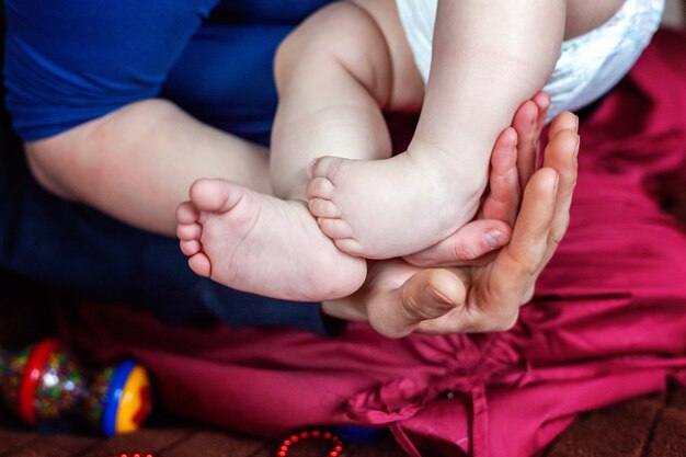 Pés de bebê nas mãos da mãe