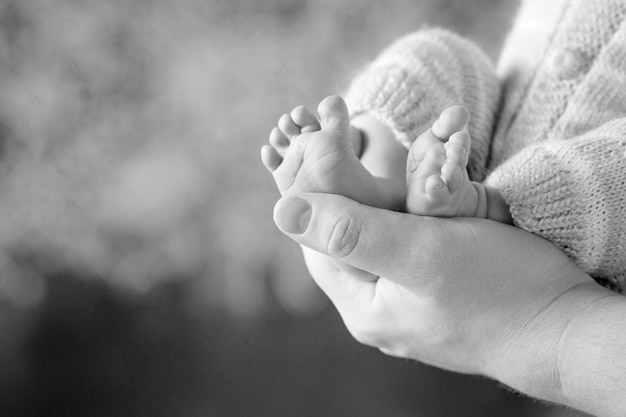 Pés de bebê nas mãos do pai Pequenos pés de bebê recém-nascido nas mãos masculinas pai e filho Família feliz