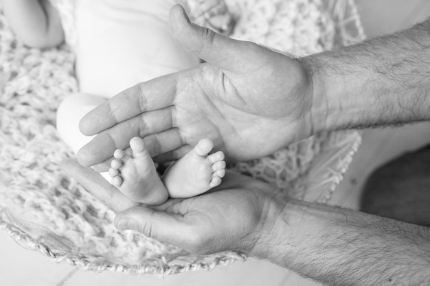 Pés de bebê nas mãos do pai pequenos pés de bebê recém-nascido nas mãos masculinas pai e filho