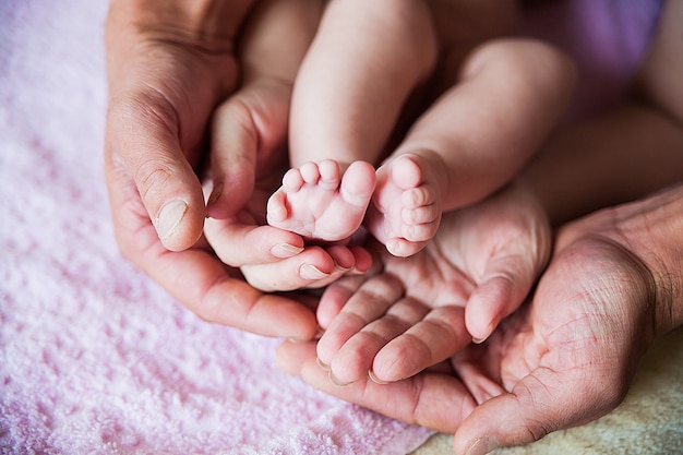 Pés de bebê nas mãos do pai