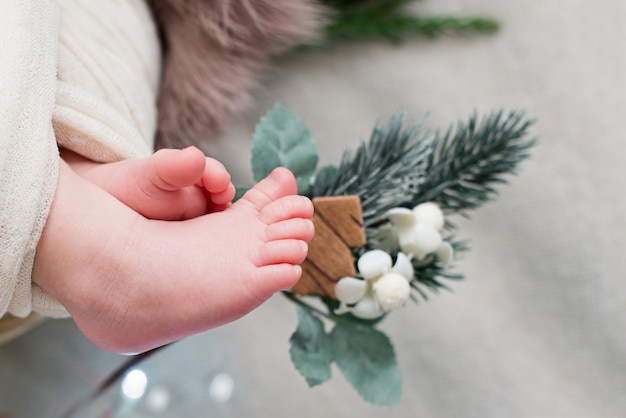 Pés de bebê recém-nascido com decorações de Natal.