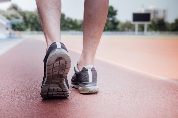 Pés de corredor de atleta correndo na pista de estrada