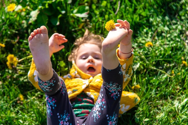 Pés de criança na grama no jardim primavera-leão Foco seletivo