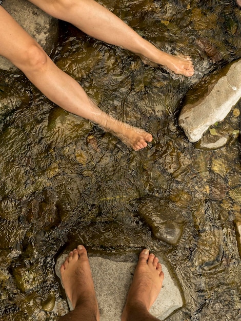 pés de homem e mulher no rio