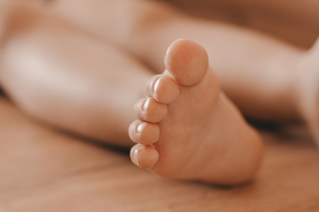 Foto pés de uma criança pequena sobre um fundo de madeira sólida - dedos do pé