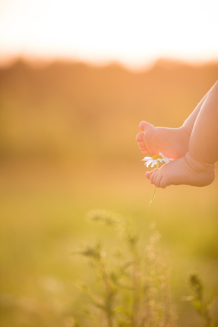 Pés descalços de um bebê fofo no fundo de verão Infância na fazenda