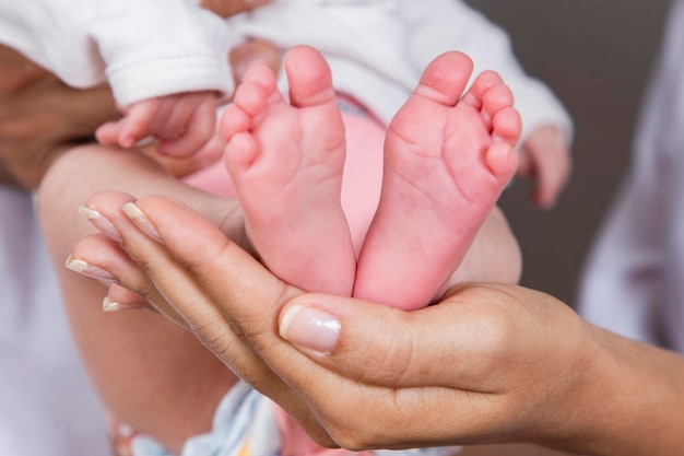 Pés do bebê nas mãos da mãe Mãe e seu filho Conceito de família feliz Linda imagem conceitual da maternidade