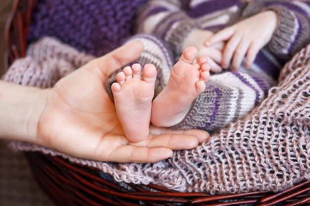 Pés do bebê nas mãos da mãe.