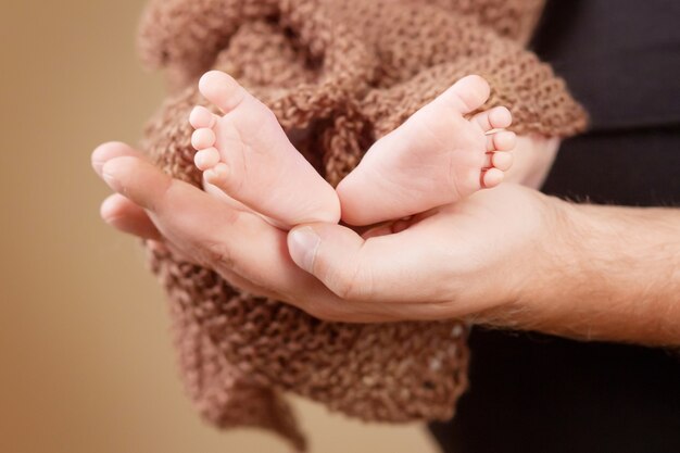 Foto pés do bebê nas mãos do pai. papai e seu filho. conceito de família feliz. bela imagem conceitual da paternidade