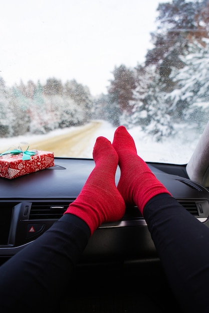 Pés femininos no carro no inverno