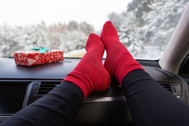 Pés femininos no carro no inverno