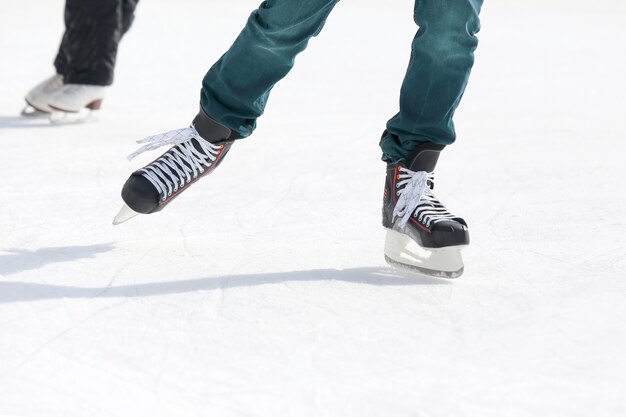 Pés patinando na pista de gelo. Esporte e entretenimento. Descanso e férias de inverno.