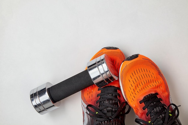 Foto una pesa metálica cayó sobre los pies de un atleta con zapatillas naranjas precauciones de seguridad al entrenar con equipos pesados