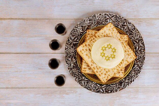 Pesah celebración navideña, pan sin levadura matza y cuatro tazas de vino kosher