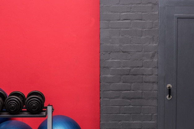 Foto pesas y pelotas de ejercicio en frente de una pared