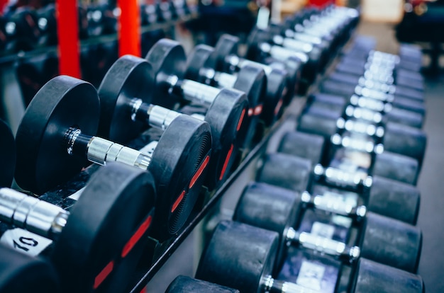 Pesas pesadas metálicas negras en el stand en el gimnasio