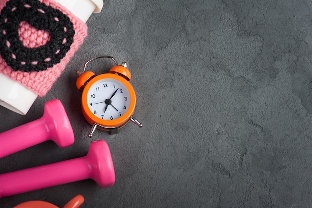 Foto pesas, taza de agua y reloj despertador