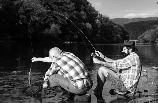 Foto pesca com mosca no deserto prístino do canadá pescador pescando em um rio com uma vara de pesca gerações velhas avô e pai