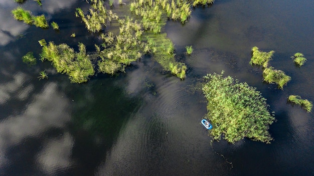 Pesca de barco azul inflável em um lago florestal Vista aérea de drone