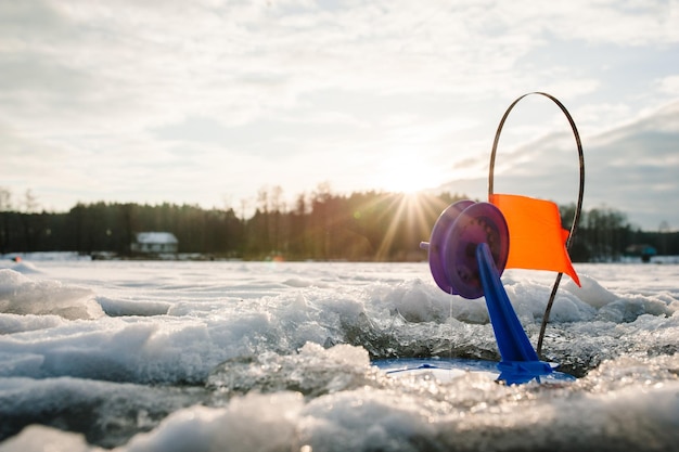 Pesca de inverno para pique no peixe de imitação no lago congelado Pequeno equipamento para pesca de inverno na lagoa de gelo Bobina para um peixe no buraco de gelo com uma bandeira