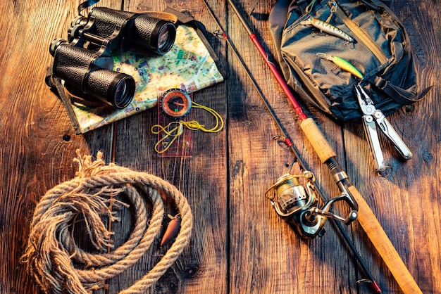 Pesca girando con una cuerda de carrete Artículos de pesca en un fondo de madera Binoculares y cuerda