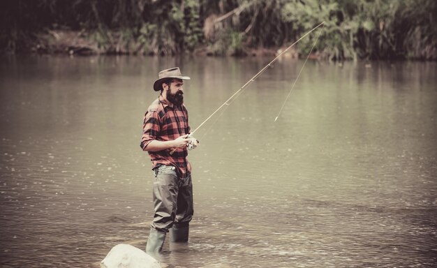 La pesca masculina en el lago se relaja en el entorno natural, las buenas ganancias continúan con la pesca, el hombre se relaja y