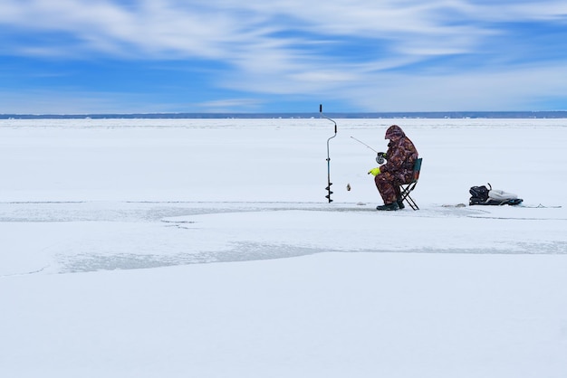 Pesca no gelo homem solitário pesca de perca pesca de inverno como hobby atividade de inverno na escandinávia