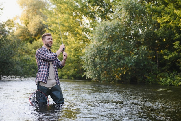 Pesca Pescador y trucha Pescador en río salvaje