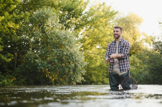 Pesca Pescador y trucha Pescador en río salvaje