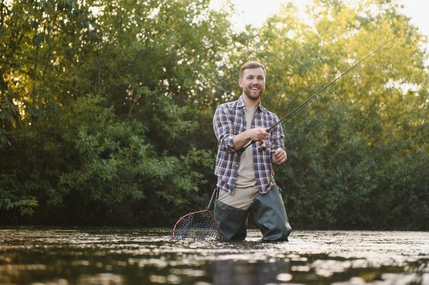 Pesca Pescador y trucha Pescador en río salvaje