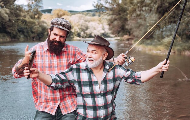 Pesca en el río retrato de alegres dos hombres barbudos pescando diferencia entre pesca con mosca y reg