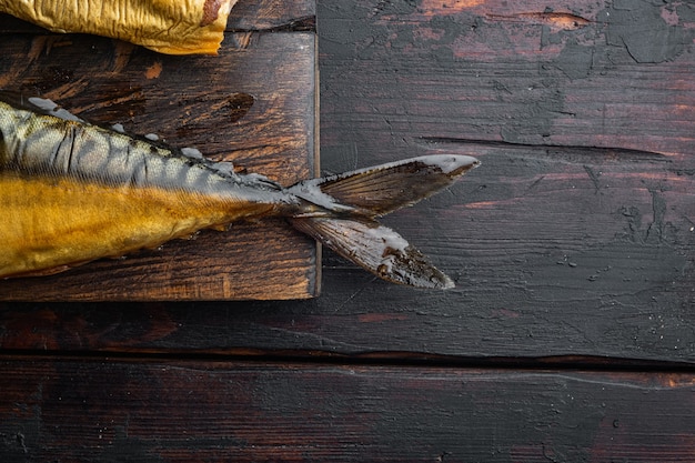 Pescado ahumado apetitoso caballa, sobre fondo de mesa de madera oscura antigua, vista superior plana con espacio para copiar texto