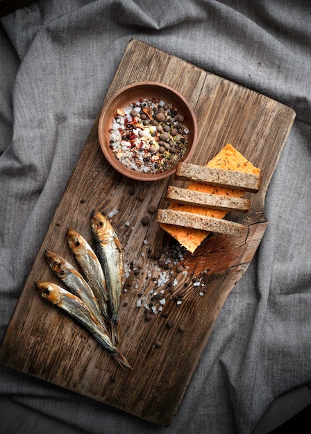 Pescado ahumado en frío sobre una vieja tabla de madera con especias