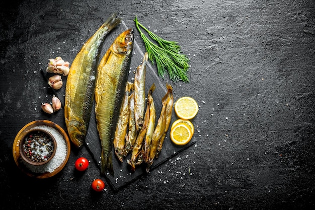 Pescado ahumado con rodajas de limón y eneldo y dientes de ajo