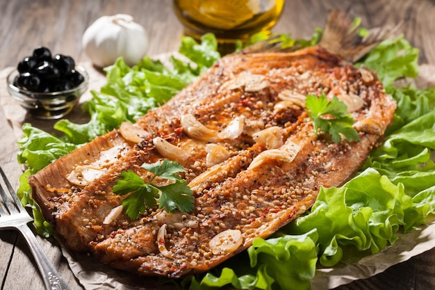 Pescado ahumado con verduras en mesa de madera