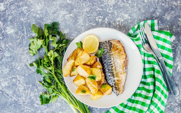 Pescado al horno caballa y papas. Enfoque selectivo