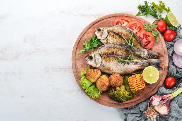 Pescado al horno con especias y verduras Carpa Sobre un fondo de madera Vista superior Espacio de copia