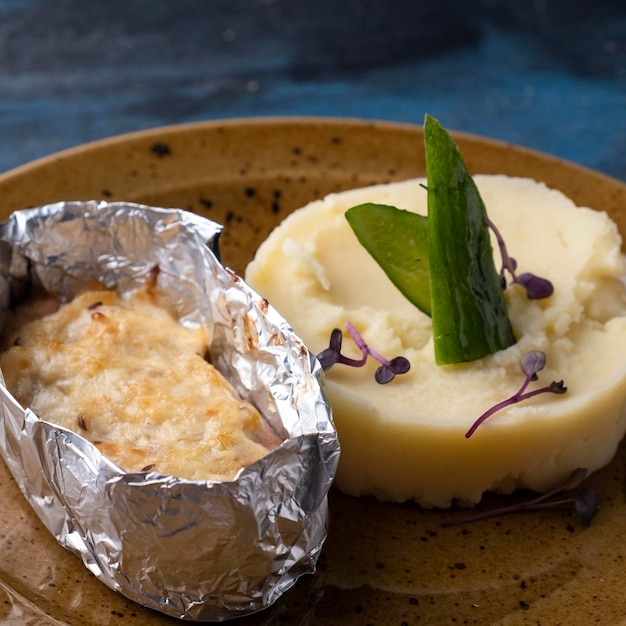 Pescado al horno bajo queso con puré de patata