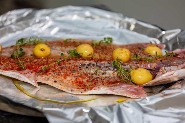 Pescado de anchoa tradicional Pomatomus saltador sazonado listo para hornear en el horno